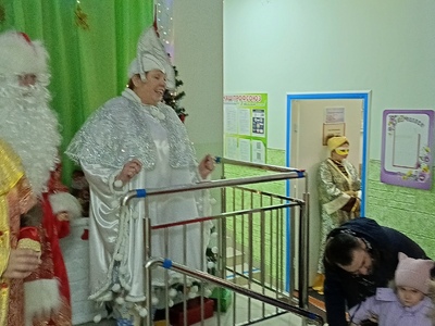 В последний день уходящего года Дед Мороз и его свита встречает родителей и сотрудников при входе в детский сад